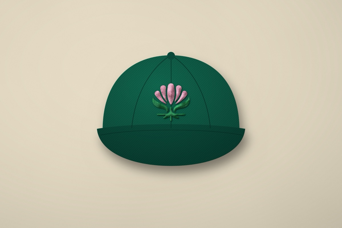 A green cap with the pink and green Bloom flower stitched on the front.