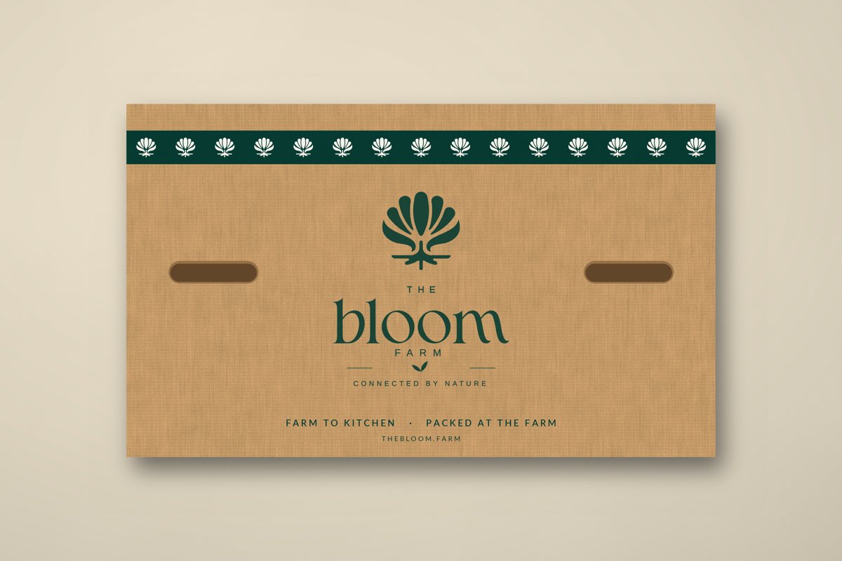 A cardboard Bloom Farm box with a row of bloom marks across the top, the Bloom Farm logo, and the words Farm to kitchen, packed at the farm.